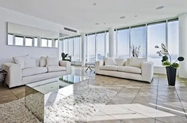 Modern white living room with large windows.