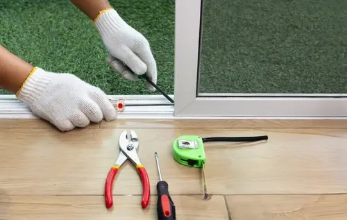 Handyman fixing a broken screen door.