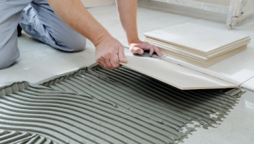Worker laying floor tiles.