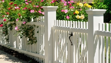 White fence with colorful flowers.